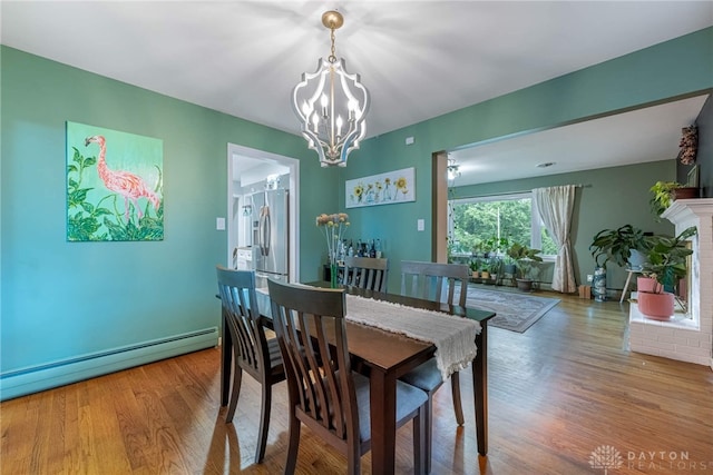 3105 Shadow Hill Rd, Middletown, OH 45042 - dining space with a baseboard radiator, a chandelier, and wood finished floors