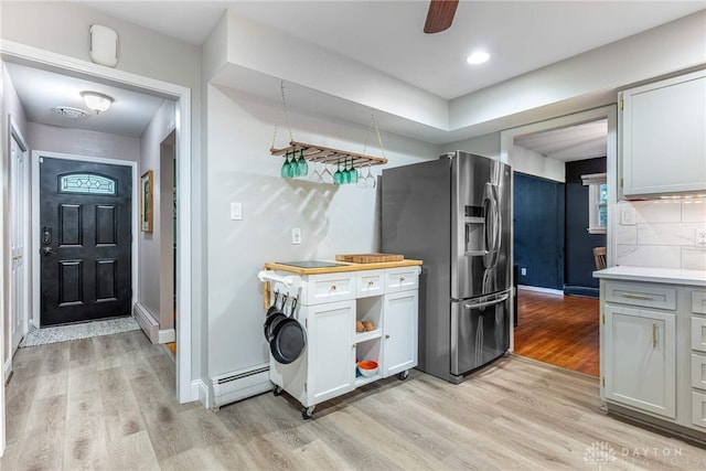 3105 Shadow Hill Rd, Middletown, OH 45042 - kitchen featuring stainless steel fridge, baseboard heating, light wood-style flooring, decorative backsplash, and light countertops