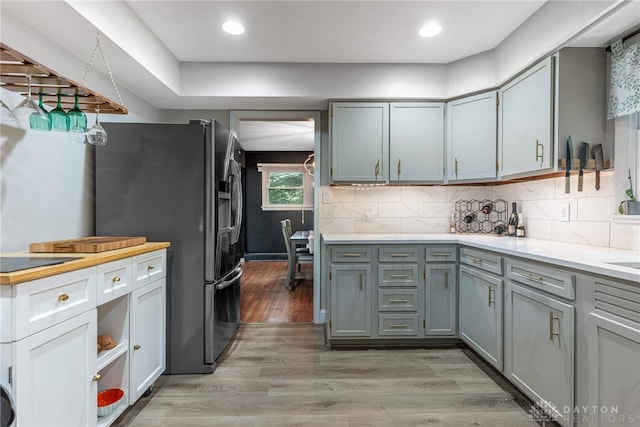 3105 Shadow Hill Rd, Middletown, OH 45042 - kitchen featuring light wood finished floors, light countertops, gray cabinets, tasteful backsplash, and stainless steel refrigerator with ice dispenser