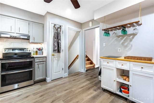 3105 Shadow Hill Rd, Middletown, OH 45042 - kitchen featuring range with two ovens, under cabinet range hood, a ceiling fan, light wood finished floors, and tasteful backsplash
