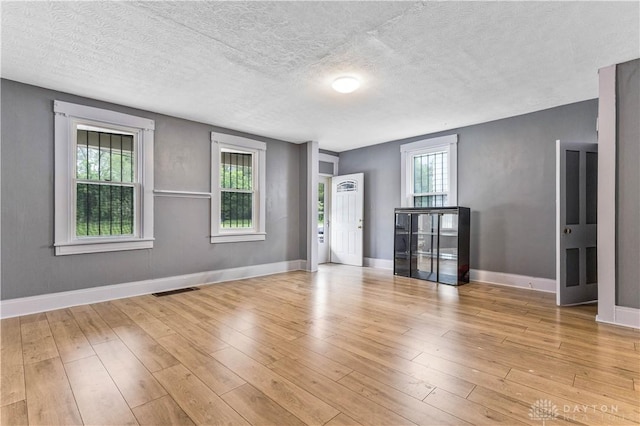 119 Wilson St, Hamilton, OH 45011 - empty room featuring healthy amount of natural light, wood finished floors, and a textured ceiling