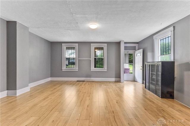 119 Wilson St, Hamilton, OH 45011 - unfurnished living room with light wood-style floors and a textured ceiling