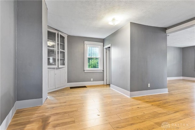 119 Wilson St, Hamilton, OH 45011 - unfurnished room featuring a textured ceiling, light wood finished floors, and built in features