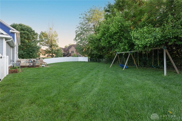 2610 Yorktown Ct, Beavercreek, OH 45434 - yard at dusk featuring a playground, a fenced backyard, and a wooden deck