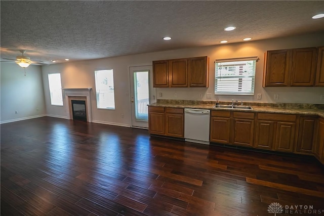 2710 Zoellners Way, Fairfield Twp, OH 45011 - kitchen featuring dishwasher, brown cabinets, ceiling fan, a glass covered fireplace, and a textured ceiling