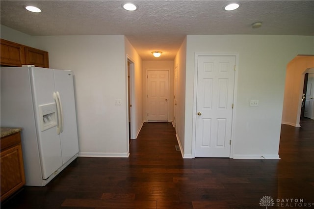2710 Zoellners Way, Fairfield Twp, OH 45011 - kitchen featuring white fridge with ice dispenser, wood finished floors, brown cabinetry, arched walkways, and recessed lighting