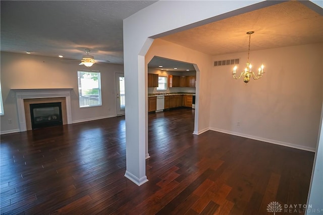 2710 Zoellners Way, Fairfield Twp, OH 45011 - unfurnished living room featuring a ceiling fan, dark wood-type flooring, a chandelier, a glass covered fireplace, and plenty of natural light