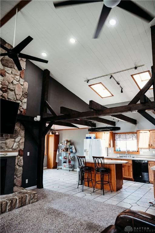 916 Wilson Rd, Troy, OH 45373 - kitchen featuring black dishwasher, a ceiling fan, white fridge with ice dispenser, a kitchen breakfast bar, and high vaulted ceiling