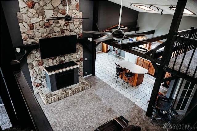 916 Wilson Rd, Troy, OH 45373 - living room featuring a ceiling fan, a fireplace, rail lighting, and tile patterned flooring