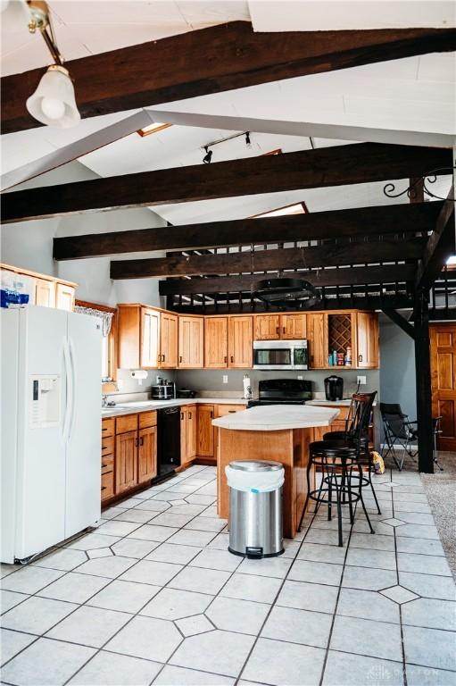 916 Wilson Rd, Troy, OH 45373 - kitchen with white refrigerator with ice dispenser, stainless steel microwave, dishwasher, range with electric stovetop, and light countertops