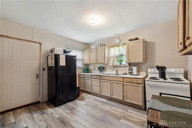 711 E 2nd St, Xenia, OH 45385 - kitchen with freestanding refrigerator, white electric stove, light countertops, and healthy amount of natural light