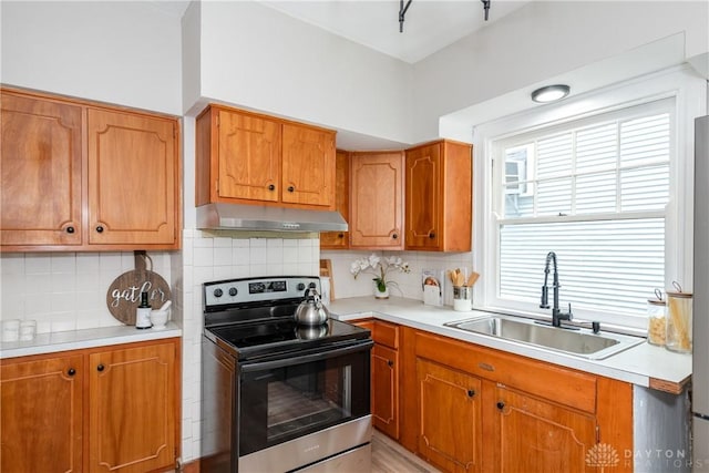 331 Illinois Ave, Dayton, OH 45410 - kitchen featuring stainless steel electric range oven, under cabinet range hood, light countertops, brown cabinetry, and decorative backsplash