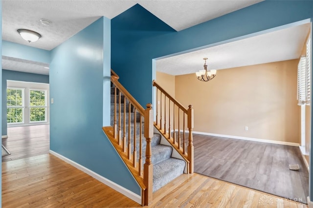 110 Easton Manor Dr, Monroe, OH 45050 - stairs featuring wood finished floors, a chandelier, and a textured ceiling