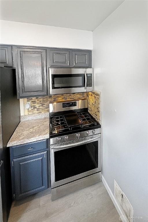 400 S Hayden Ave, Riverside, OH 45431 - kitchen featuring appliances with stainless steel finishes, backsplash, light countertops, and gray cabinets