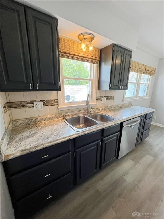 400 S Hayden Ave, Riverside, OH 45431 - kitchen with light wood finished floors, dishwasher, light countertops, dark cabinetry, and tasteful backsplash