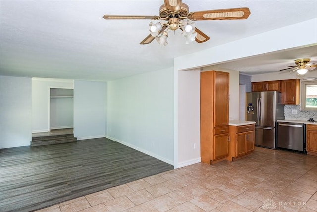 4155 Eckworth, Bellbrook, OH 45305 - kitchen featuring appliances with stainless steel finishes, a ceiling fan, brown cabinets, light countertops, and tasteful backsplash