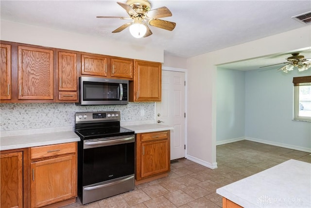 4155 Eckworth, Bellbrook, OH 45305 - kitchen with appliances with stainless steel finishes, a ceiling fan, light countertops, brown cabinets, and tasteful backsplash