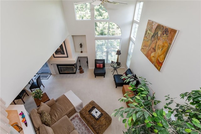 3917 E Summit Ridge Dr, Beavercreek, OH 45430 - carpeted living area with a ceiling fan, a towering ceiling, and a glass covered fireplace