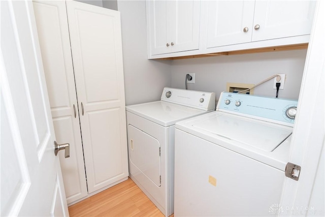 3917 E Summit Ridge Dr, Beavercreek, OH 45430 - laundry area with washer and clothes dryer, cabinet space, and light wood-type flooring
