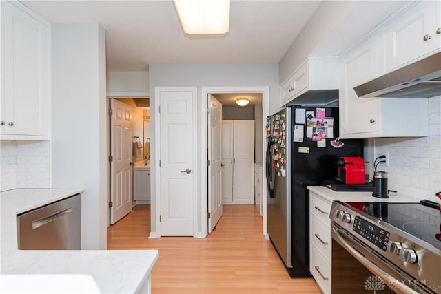 3917 E Summit Ridge Dr, Beavercreek, OH 45430 - kitchen with stainless steel appliances, white cabinetry, light wood-style floors, light countertops, and ventilation hood