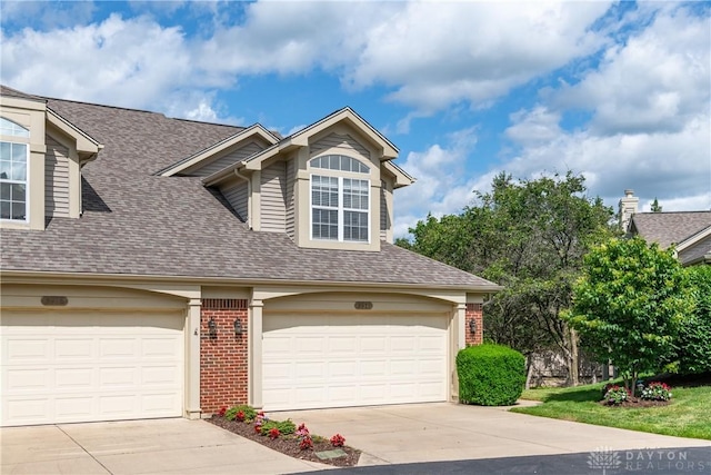 3917 E Summit Ridge Dr, Beavercreek, OH 45430 - view of front facade with a shingled roof, concrete driveway, brick siding, and a garage