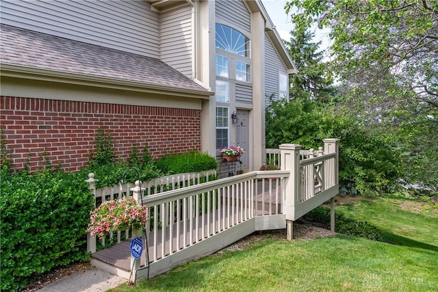 3917 E Summit Ridge Dr, Beavercreek, OH 45430 - view of exterior entry with a shingled roof, a yard, brick siding, and a wooden deck