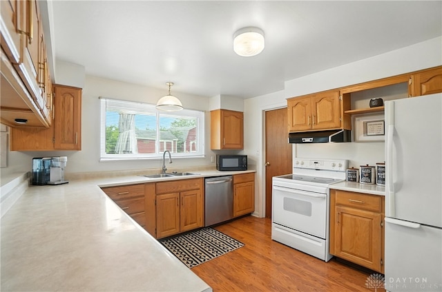 903 Meadow Ln, Lebanon, OH 45036 - kitchen featuring white appliances, under cabinet range hood, light countertops, decorative light fixtures, and light wood finished floors