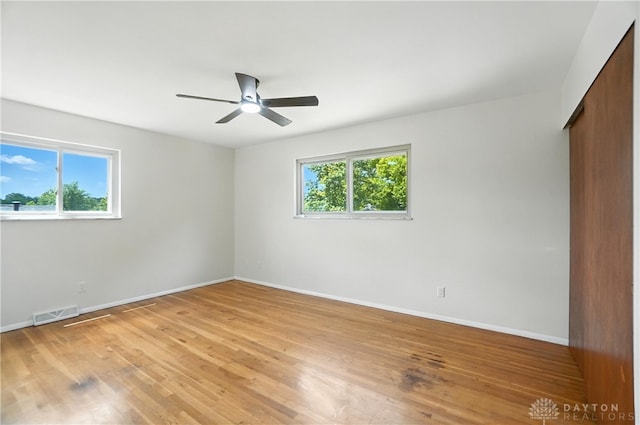 1023 Hilliard Dr, Delhi Twp, OH 45238 - unfurnished bedroom with multiple windows, light wood finished floors, and a ceiling fan