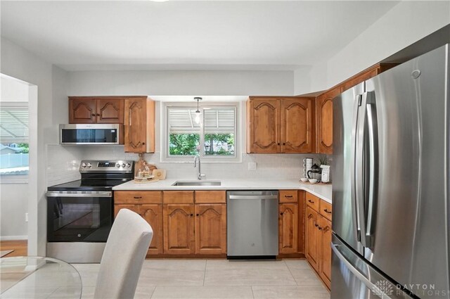 1023 Hilliard Dr, Delhi Twp, OH 45238 - kitchen featuring appliances with stainless steel finishes, brown cabinets, tasteful backsplash, and light countertops