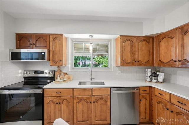 1023 Hilliard Dr, Delhi Twp, OH 45238 - kitchen featuring stainless steel appliances, brown cabinets, tasteful backsplash, and light countertops