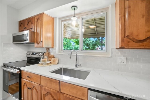 1023 Hilliard Dr, Delhi Twp, OH 45238 - kitchen with appliances with stainless steel finishes, decorative backsplash, light stone counters, and brown cabinets