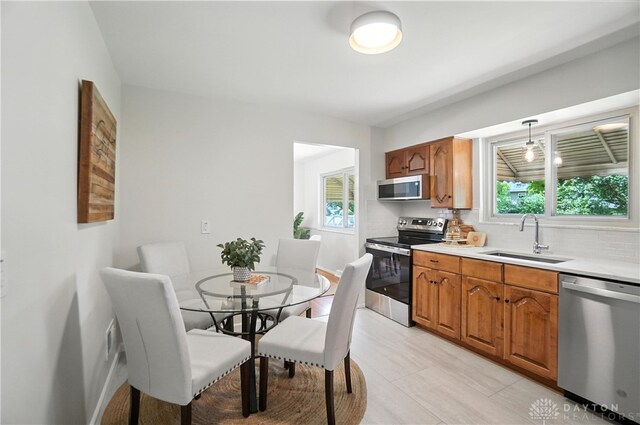 1023 Hilliard Dr, Delhi Twp, OH 45238 - kitchen with stainless steel appliances, plenty of natural light, light countertops, and brown cabinetry