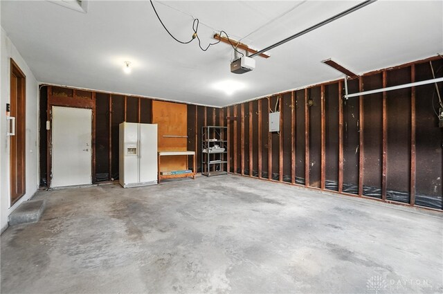 1023 Hilliard Dr, Delhi Twp, OH 45238 - garage featuring white refrigerator with ice dispenser and a garage door opener
