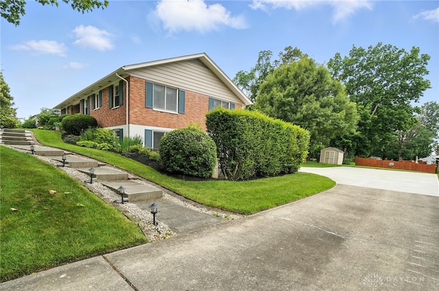 1804 Schirm Dr, Middletown, OH 45042 - view of side of property featuring a storage shed, brick siding, a lawn, and concrete driveway