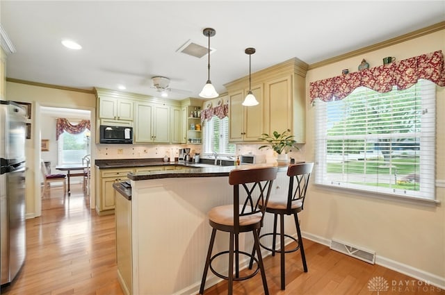 1804 Schirm Dr, Middletown, OH 45042 - kitchen with black microwave, freestanding refrigerator, light wood-type flooring, open shelves, and a kitchen bar
