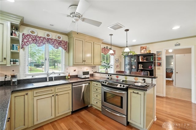 1804 Schirm Dr, Middletown, OH 45042 - kitchen featuring appliances with stainless steel finishes, cream cabinets, a peninsula, ceiling fan, and ornamental molding