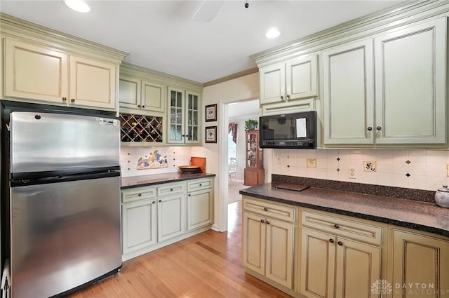 1804 Schirm Dr, Middletown, OH 45042 - kitchen featuring freestanding refrigerator, black microwave, cream cabinetry, light wood-style floors, and dark countertops
