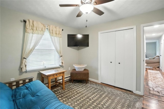 8425 Dillman Rd, Camden, OH 45311 - bedroom featuring wood finished floors, a closet, a baseboard radiator, and ceiling fan