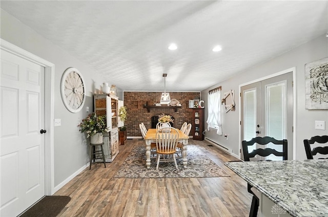 8425 Dillman Rd, Camden, OH 45311 - dining room featuring wood finished floors, recessed lighting, brick wall, and a baseboard heating unit