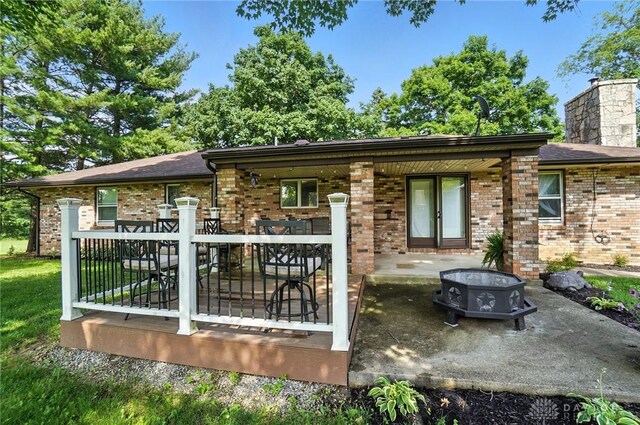 8425 Dillman Rd, Camden, OH 45311 - back of house featuring brick siding, a patio area, and a chimney