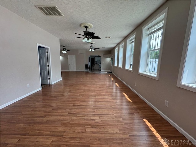 523 Newport Rd, Xenia, OH 45385 - unfurnished living room with a textured ceiling, arched walkways, ceiling fan, and dark wood-style flooring