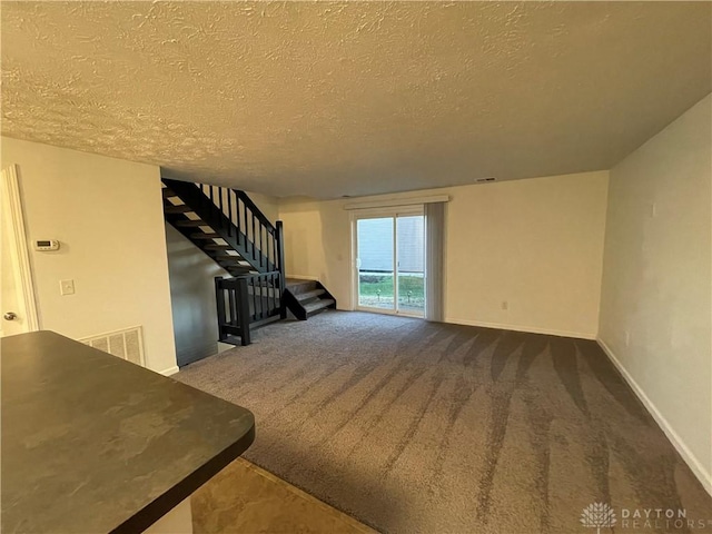 2133 Chapel Dr, Fairborn, OH 45324 - unfurnished living room with stairs, a textured ceiling, and carpet flooring