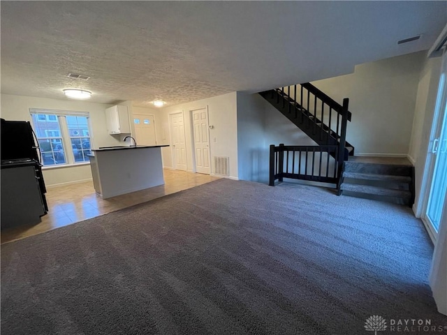 2133 Chapel Dr, Fairborn, OH 45324 - unfurnished living room with stairway, light carpet, and a textured ceiling
