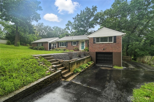 945 Oakland Dr, Beavercreek Twp, OH 45434 - view of front of house with driveway, a garage, brick siding, a front lawn, and stairway