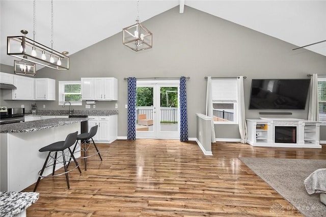 2858 Willow Ridge Dr, Colerain Twp, OH 45251 - kitchen featuring high vaulted ceiling, light wood-style floors, a chandelier, white cabinetry, and decorative light fixtures