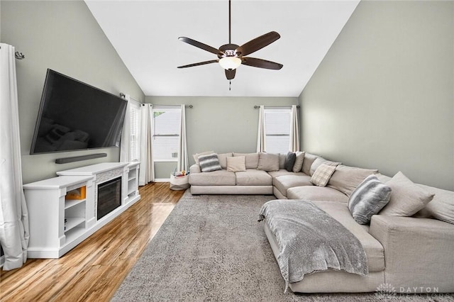 2858 Willow Ridge Dr, Colerain Twp, OH 45251 - living room featuring ceiling fan, light wood-style flooring, high vaulted ceiling, and a glass covered fireplace