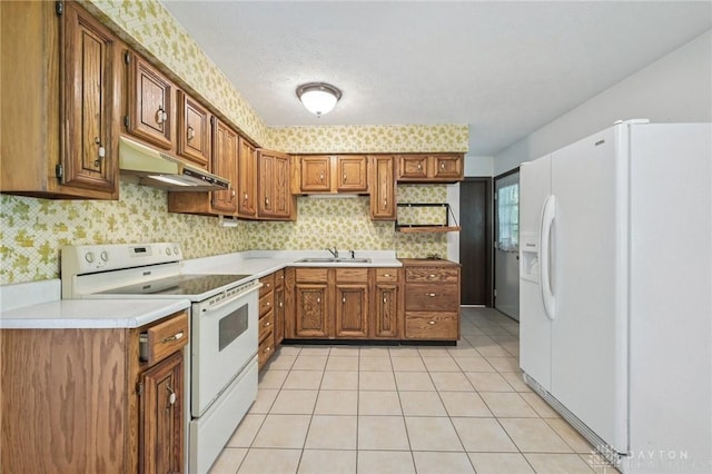 1513 Arrowhead Trl, Xenia, OH 45385 - kitchen with white appliances, under cabinet range hood, brown cabinets, and light countertops