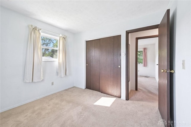 1513 Arrowhead Trl, Xenia, OH 45385 - unfurnished bedroom featuring carpet flooring, multiple windows, and a closet
