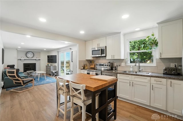 1424 Hillary Ln, Mason, OH 45040 - kitchen with stainless steel appliances, healthy amount of natural light, light wood-style floors, tasteful backsplash, and recessed lighting