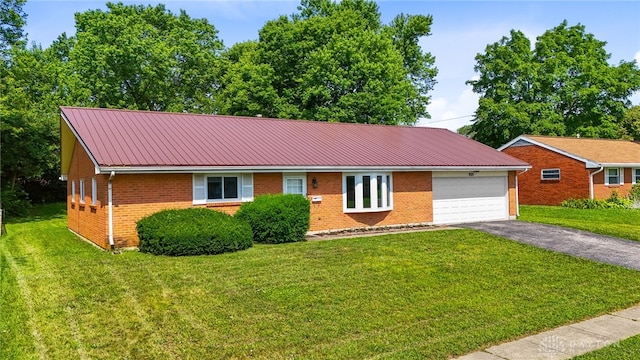 925 Robinette Ave, Vandalia, OH 45377 - ranch-style home with brick siding, asphalt driveway, an attached garage, a front lawn, and a metal roof